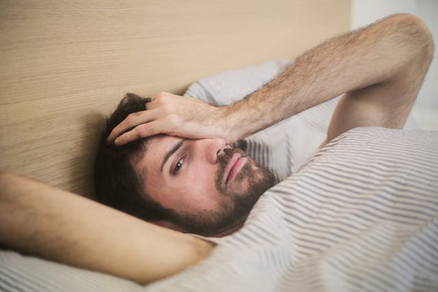 Man in pain while trying to sleep