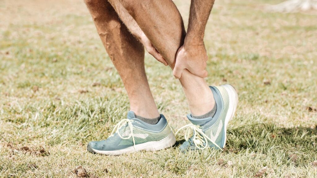 Person holding their injured leg